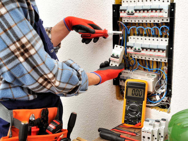 Électricien dépannant un tableau électrique dans une maison.