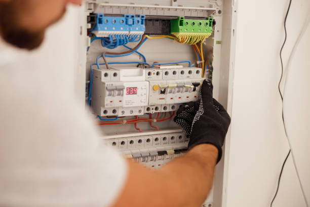 Technicien Expert : Travail de Précision dans un Tableau Électrique Technicien expert technique travaillant dans un tableau électrique.